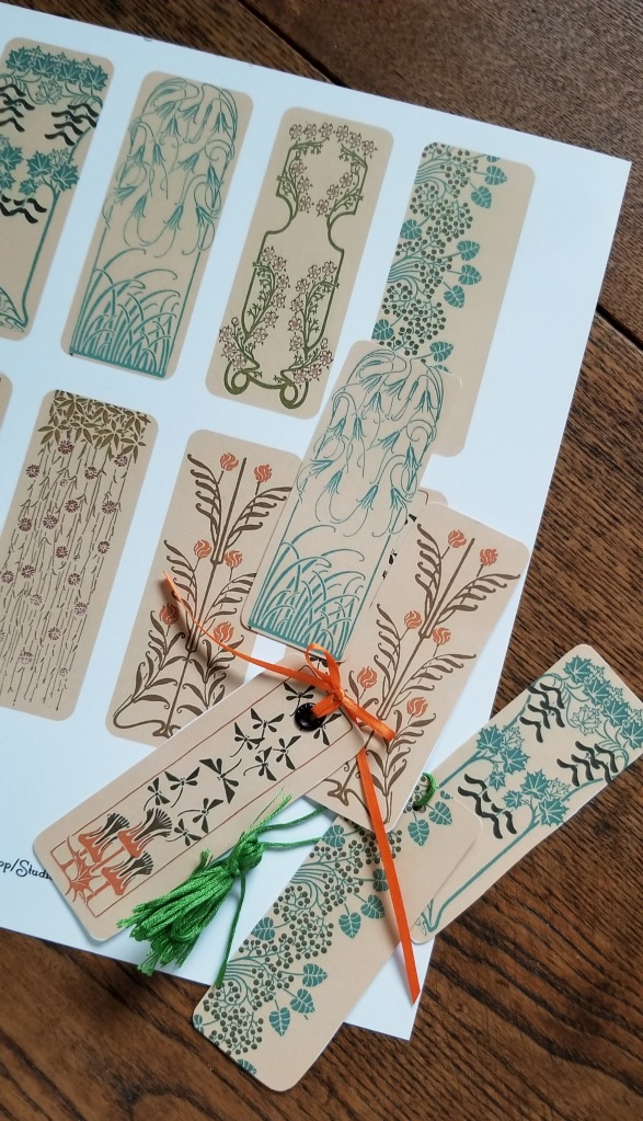 A sheet of bookmarks with finished bookmarks lying on top